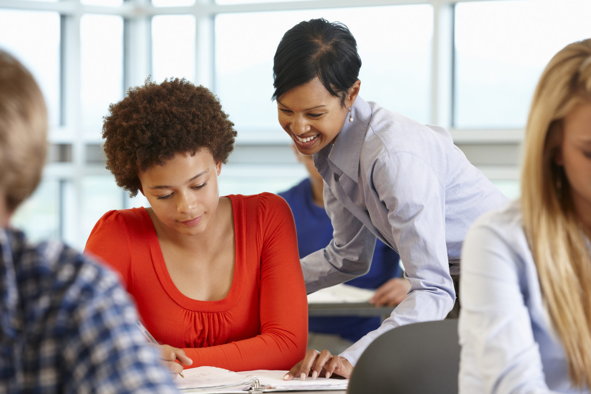 Teacher helping older female student read